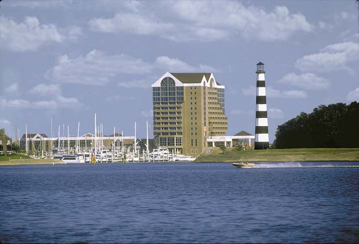 A lighthouse and some buildings near the water.